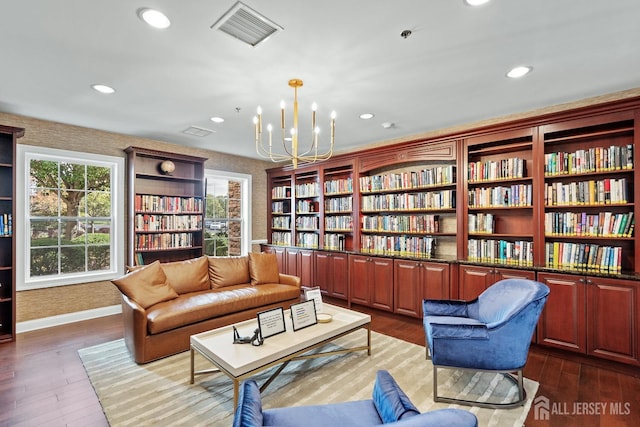 living area featuring visible vents, recessed lighting, a chandelier, dark wood-style flooring, and bookshelves