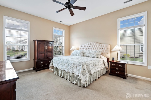 bedroom with light carpet, visible vents, and baseboards