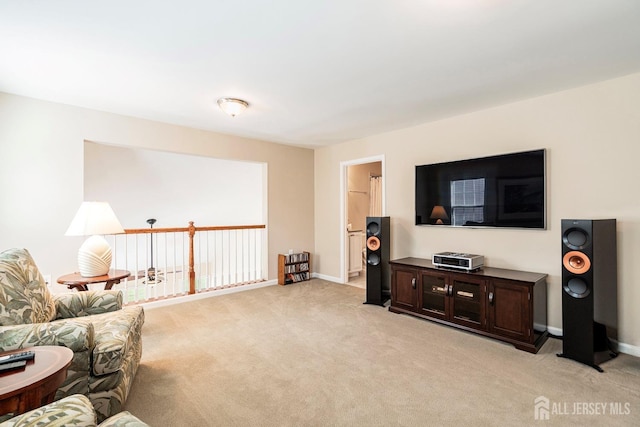 living area featuring light carpet and baseboards