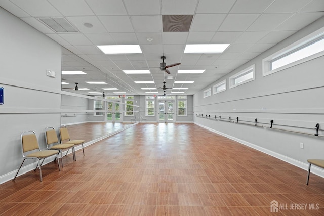 interior space featuring visible vents, baseboards, a paneled ceiling, and ceiling fan