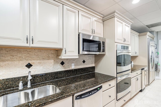 kitchen featuring a sink, decorative backsplash, dark stone countertops, and stainless steel appliances
