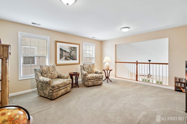 living area featuring baseboards, carpet, and visible vents