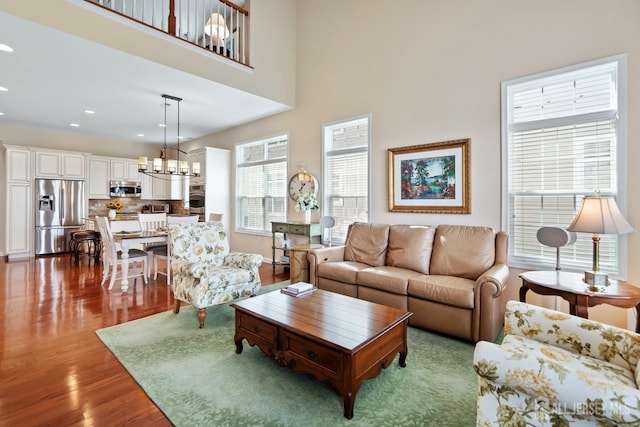 living area featuring wood finished floors, a notable chandelier, plenty of natural light, and recessed lighting