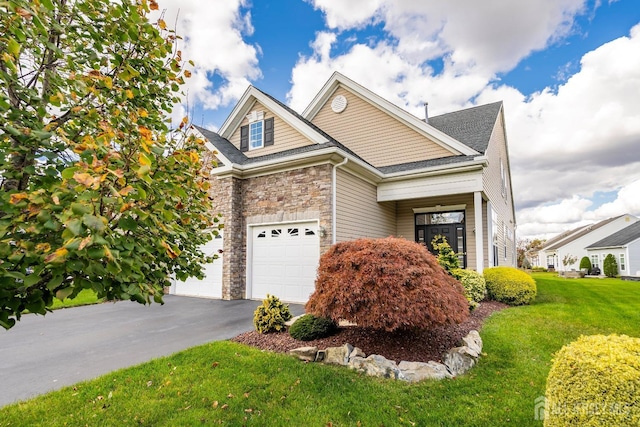 view of front of home featuring a front yard, stone siding, and driveway