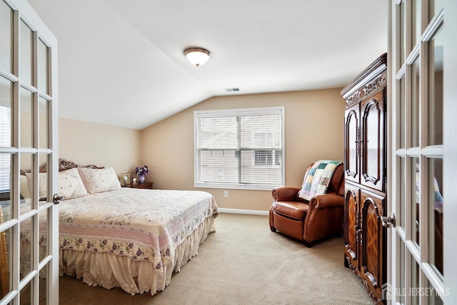 bedroom featuring baseboards, french doors, visible vents, lofted ceiling, and light colored carpet