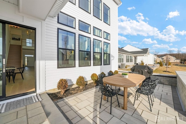 view of patio featuring outdoor dining space, a residential view, and a grill