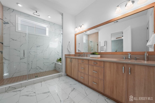 bathroom with vanity, a shower with shower door, and ceiling fan