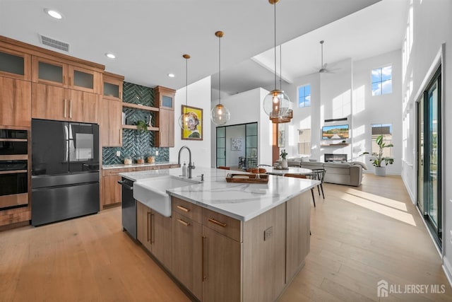 kitchen with visible vents, a center island with sink, dishwashing machine, smart refrigerator, and a sink