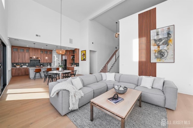 living room with light hardwood / wood-style floors and a high ceiling