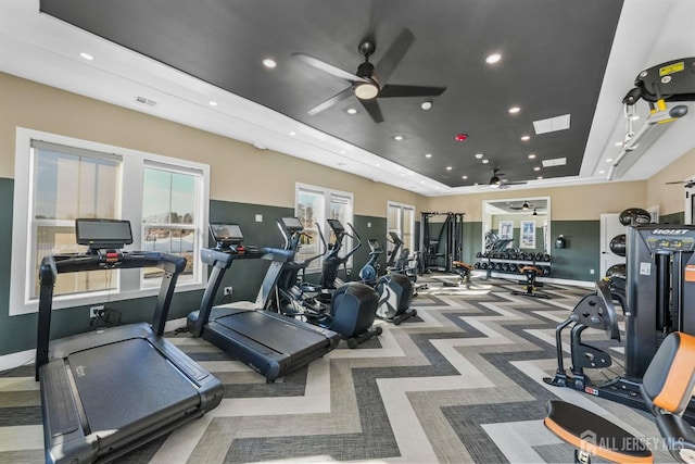 exercise room with recessed lighting, a tray ceiling, visible vents, and ceiling fan