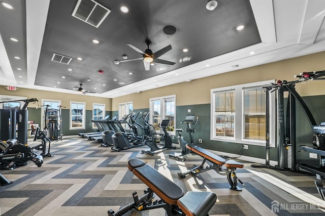 gym with visible vents, a raised ceiling, baseboards, and carpet flooring