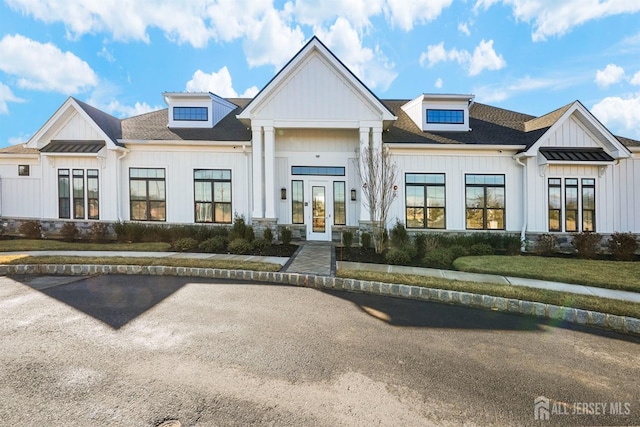 modern farmhouse style home featuring french doors, a shingled roof, board and batten siding, and metal roof