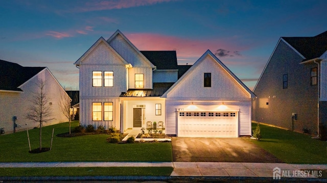 view of front of property with driveway, a standing seam roof, a front lawn, a garage, and metal roof