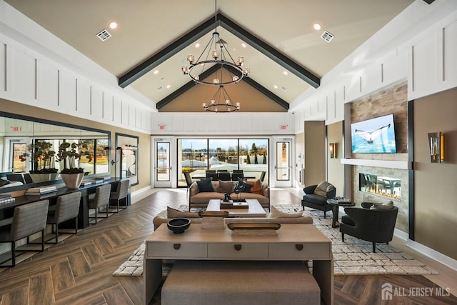 living room featuring an inviting chandelier, a fireplace, visible vents, and high vaulted ceiling