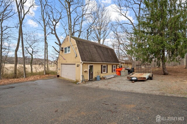 18 Back Bone Hill Rd, Millstone, NJ 08510 - view of front of home with roof with shingles, a gambrel roof, an outdoor structure, asphalt driveway, and a garage