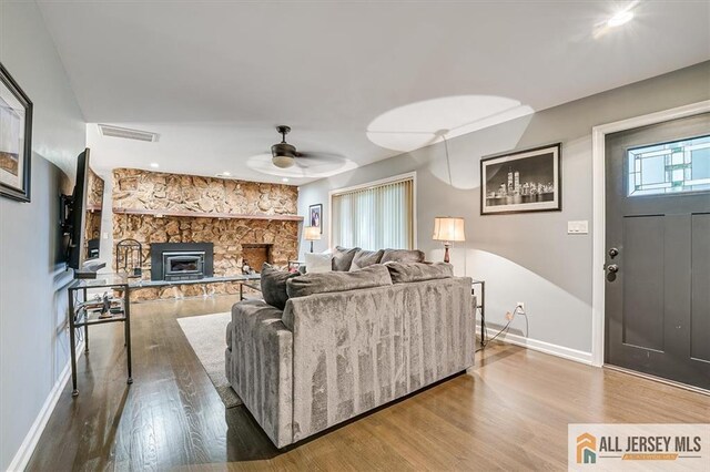 living room with hardwood / wood-style floors, a fireplace, and ceiling fan