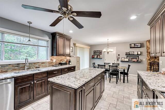 kitchen with pendant lighting, dark brown cabinetry, stainless steel appliances, and sink