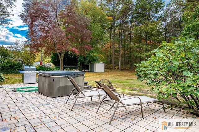 view of patio featuring a hot tub and a shed