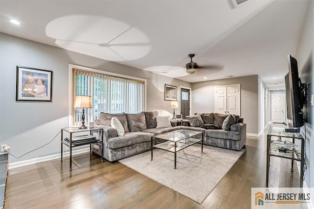 living room featuring dark wood-type flooring and ceiling fan