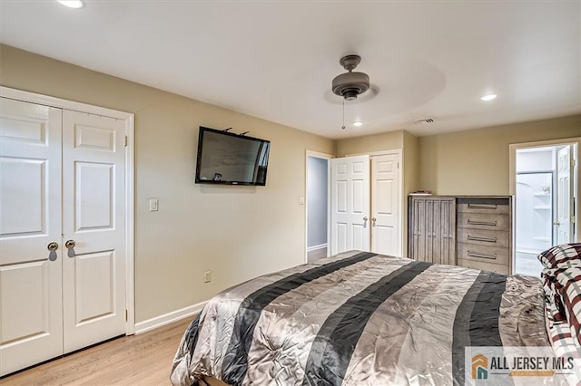 bedroom featuring multiple closets, ceiling fan, and light hardwood / wood-style flooring