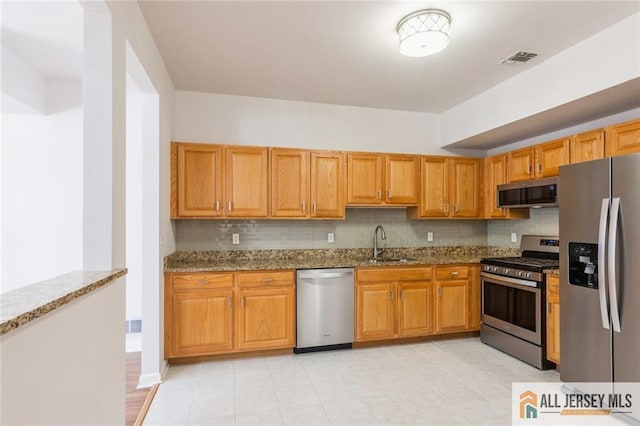 199 Pinelli Dr, Piscataway, NJ 08854 - kitchen with appliances with stainless steel finishes, dark stone countertops, decorative backsplash, and light tile patterned floors
