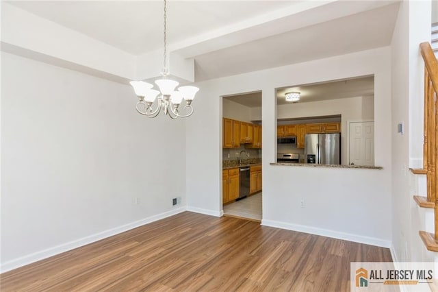 199 Pinelli Dr, Piscataway, NJ 08854 - kitchen featuring stainless steel appliances, brown cabinetry, a chandelier, wood finished floors, and tasteful backsplash