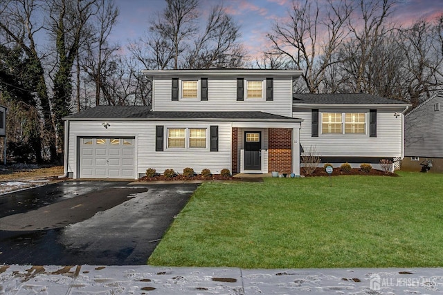 tri-level home featuring driveway, an attached garage, and a yard