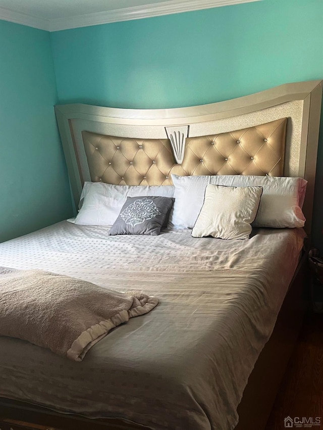 bedroom featuring hardwood / wood-style floors and ornamental molding