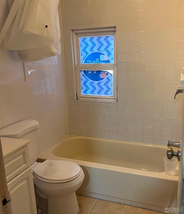 bathroom featuring vanity, tile patterned flooring, toilet, and tile walls