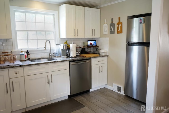 709 Wadsworth Ave, South Plainfield, NJ 07080 - kitchen with appliances with stainless steel finishes, tasteful backsplash, white cabinetry, dark stone countertops, and wood finish floors