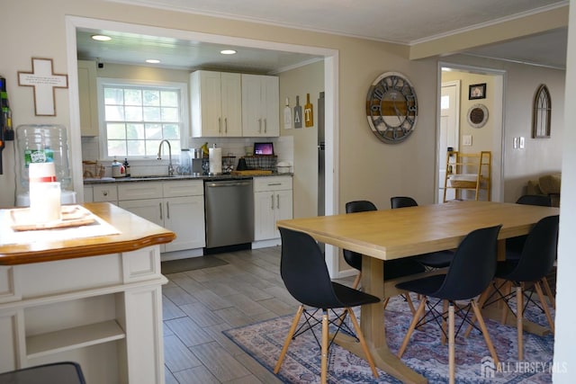 709 Wadsworth Ave, South Plainfield, NJ 07080 - kitchen with dishwasher, decorative backsplash, ornamental molding, white cabinets, and wood finished floors