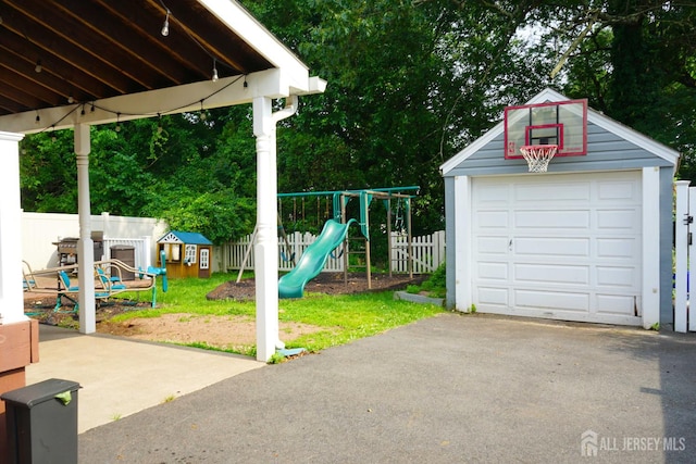 709 Wadsworth Ave, South Plainfield, NJ 07080 - view of yard with an outdoor structure, a playground, asphalt driveway, and a garage