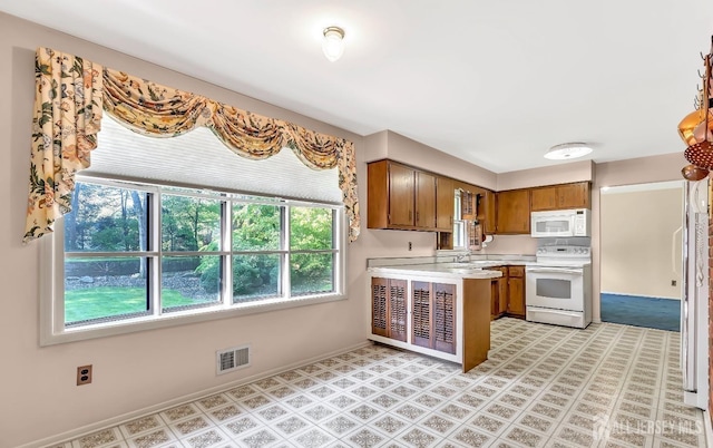 3996 Park Ave, Edison, NJ 08820 - kitchen featuring white appliances, brown cabinets, light countertops, a peninsula, and light floors