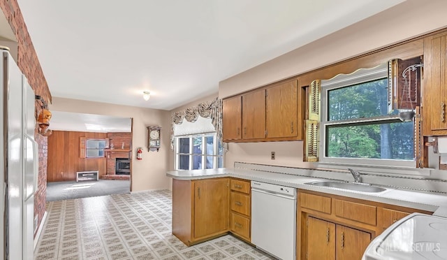 3996 Park Ave, Edison, NJ 08820 - kitchen with white dishwasher, a sink, a peninsula, a brick fireplace, and light countertops
