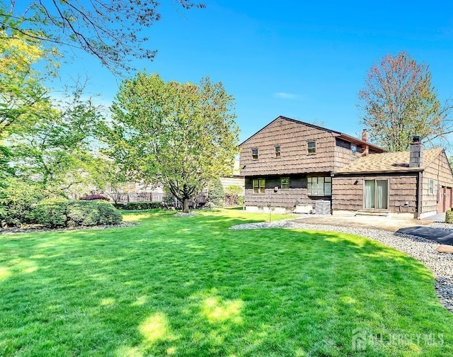 3996 Park Ave, Edison, NJ 08820 - back of property featuring a chimney, a lawn, and a patio