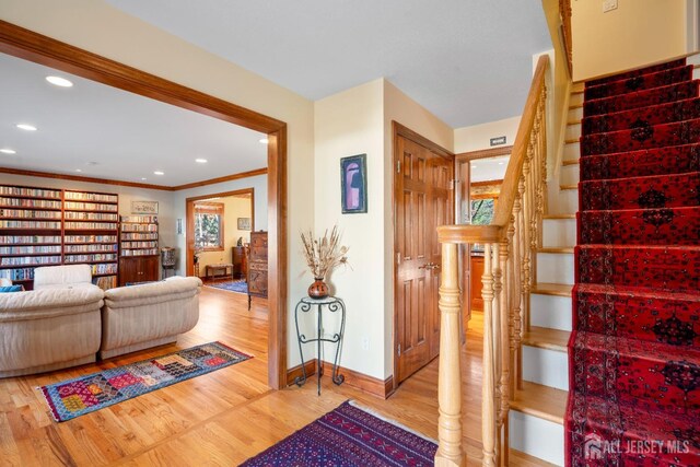 stairway featuring crown molding and wood-type flooring