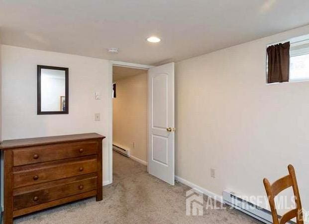 bedroom with light carpet and a baseboard radiator