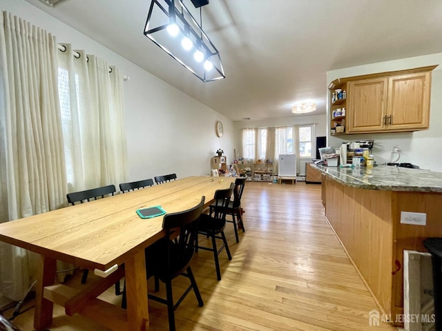 dining room featuring vaulted ceiling and light hardwood / wood-style floors