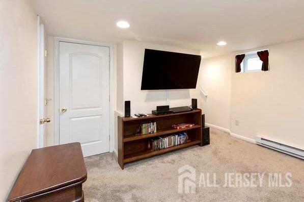 carpeted living room featuring a baseboard heating unit