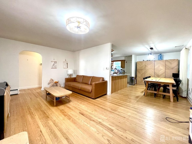 living room featuring a baseboard heating unit and light wood-type flooring