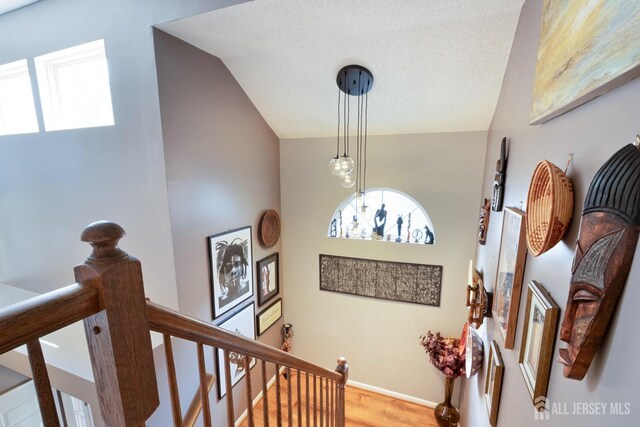 22 Fairway Blvd, Monroe, NJ 08831 - stairs with healthy amount of natural light, wood finished floors, and vaulted ceiling