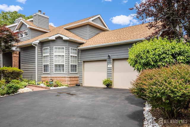 22 Fairway Blvd, Monroe, NJ 08831 - view of front facade with a shingled roof, driveway, a chimney, and an attached garage