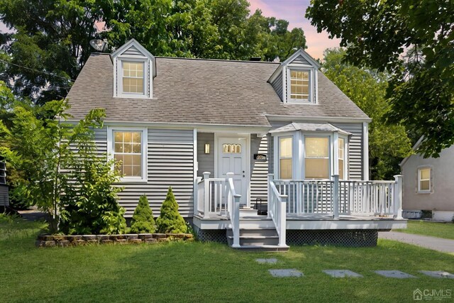 261 New Market Rd, Dunellen, NJ 08812 - cape cod home with a front lawn, a shingled roof, and a wooden deck