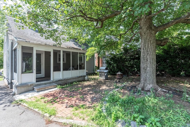 261 New Market Rd, Dunellen, NJ 08812 - view of front of home with a sunroom, roof with shingles, and a patio