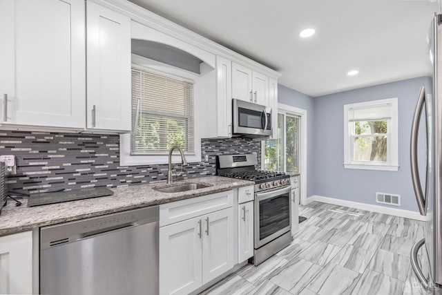 261 New Market Rd, Dunellen, NJ 08812 - kitchen featuring stainless steel appliances, tasteful backsplash, white cabinetry, light stone countertops, and recessed lighting