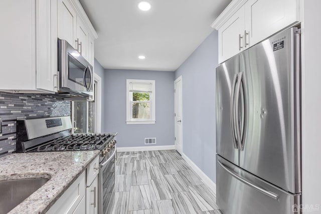 261 New Market Rd, Dunellen, NJ 08812 - kitchen with appliances with stainless steel finishes, backsplash, white cabinets, recessed lighting, and light stone counters