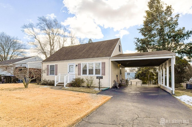 view of front of home with a carport, roof with shingles, and aphalt driveway