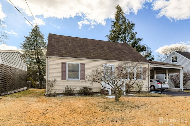 new england style home featuring an attached carport and a front lawn