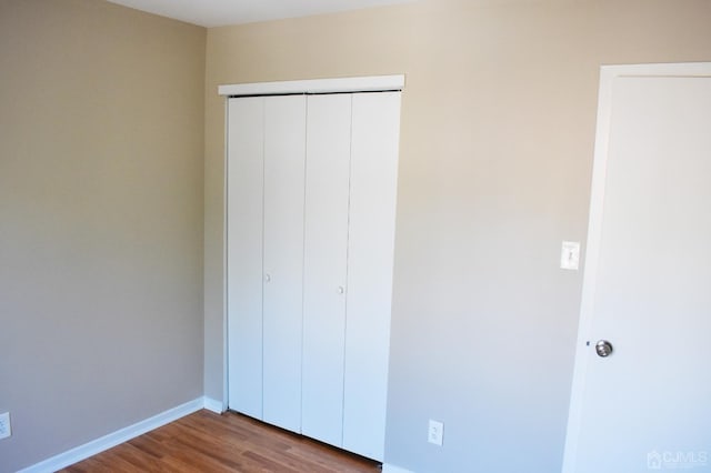 unfurnished bedroom featuring light wood-type flooring and a closet