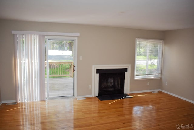 unfurnished living room with hardwood / wood-style floors and a healthy amount of sunlight